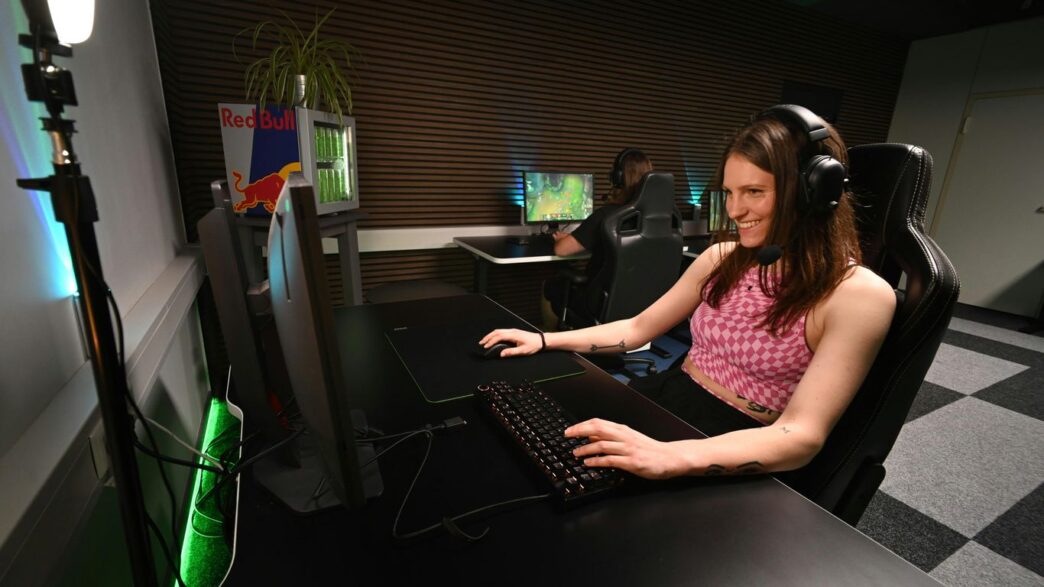 A woman sitting at a desk with headphones on