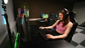 A woman sitting at a desk with headphones on
