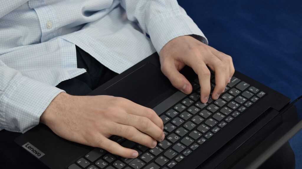 Person typing on a laptop keyboard