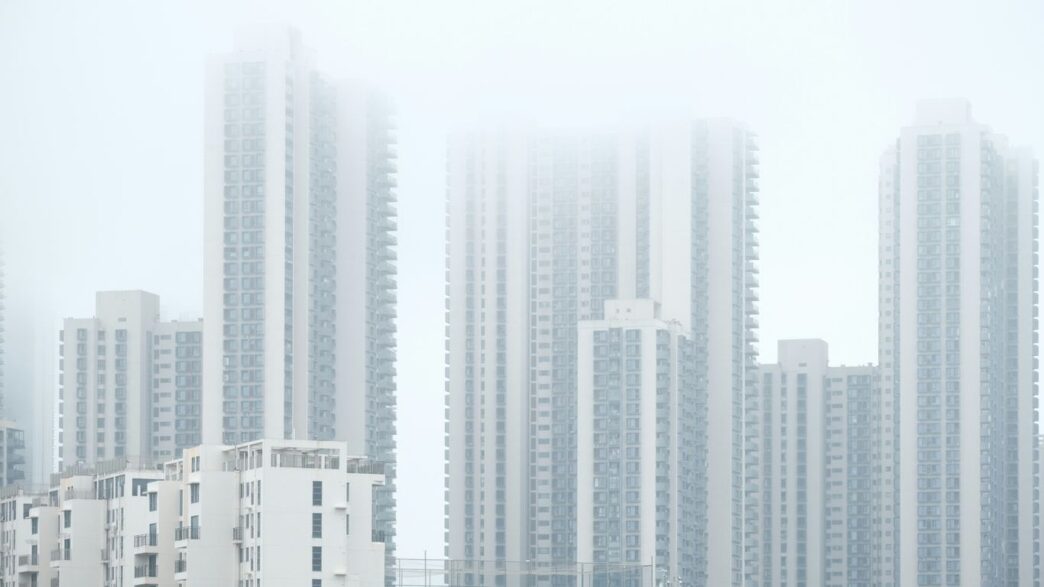 a group of tall buildings in a foggy city