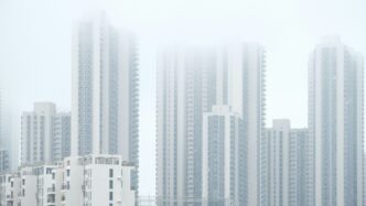 a group of tall buildings in a foggy city