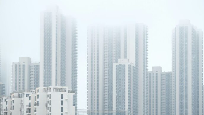 a group of tall buildings in a foggy city