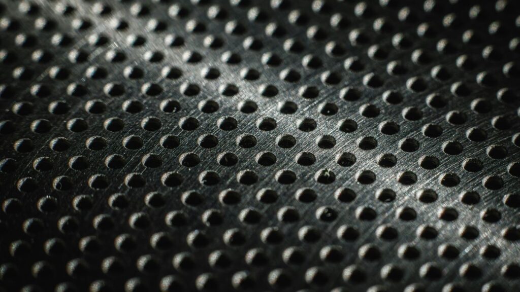 Close-up of a textured metal surface with many small holes.