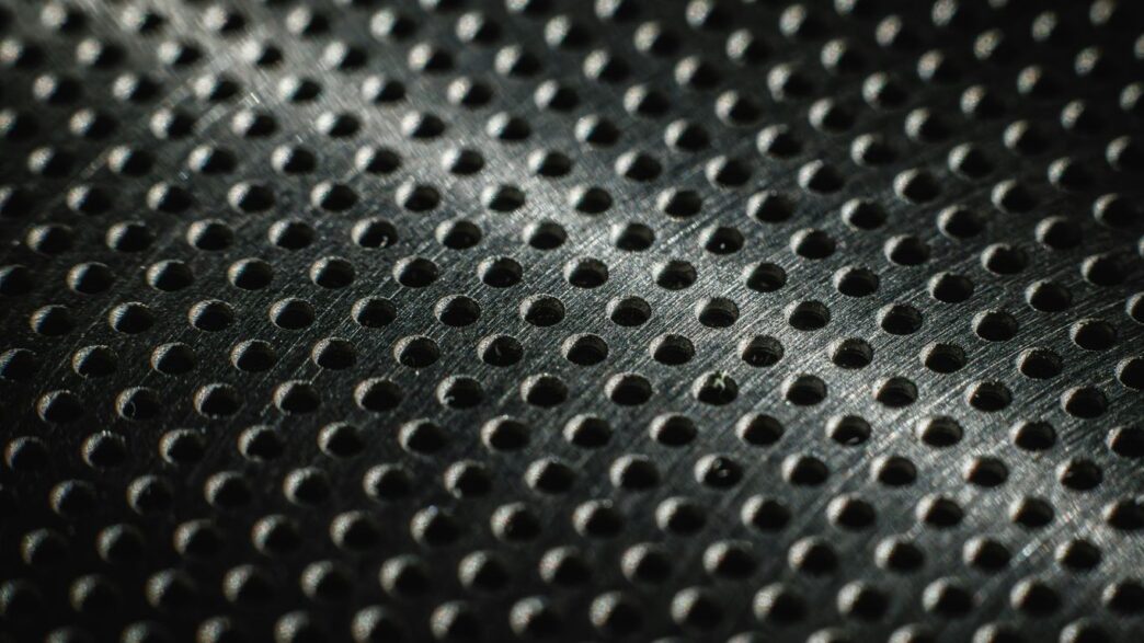 Close-up of a textured metal surface with many small holes.