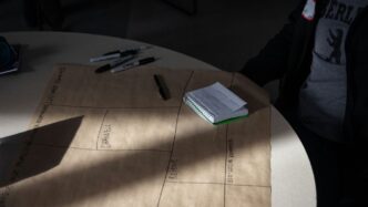 a person sitting at a table with a notebook and pen