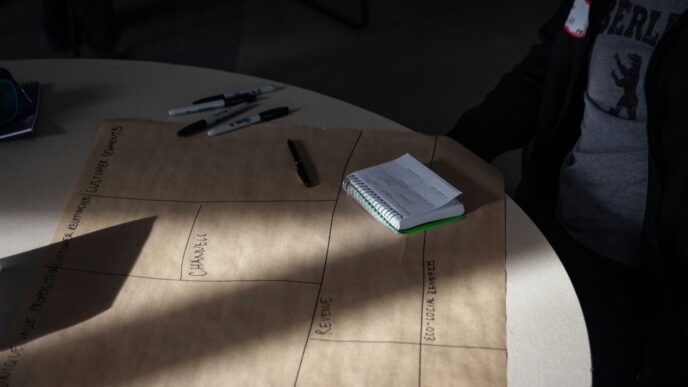 a person sitting at a table with a notebook and pen