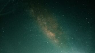 a person standing on a hill under a night sky