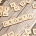 scrabbled letters spelling growth on a wooden surface