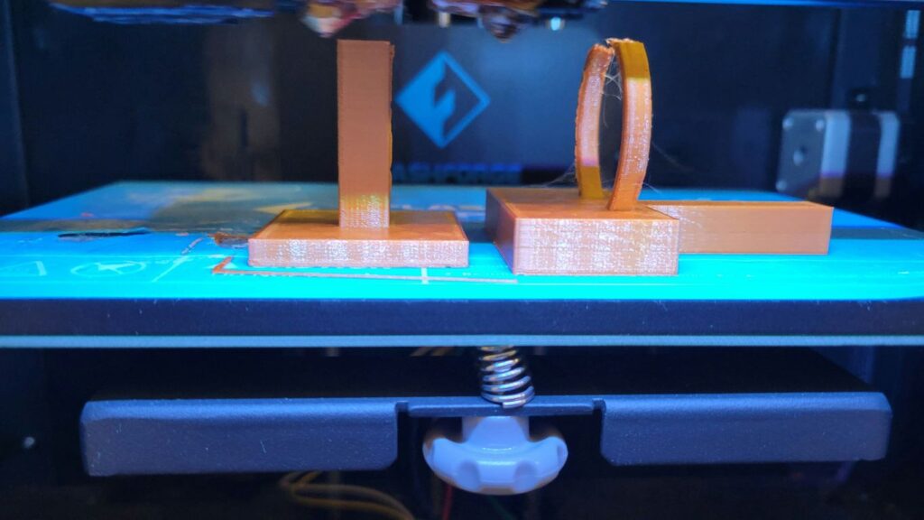 A 3D printer with two boxes attached to it