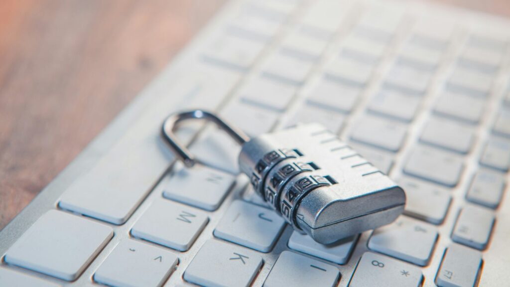 A combination lock rests on a computer keyboard.