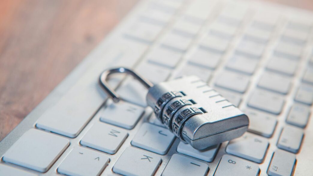 A combination lock rests on a computer keyboard.