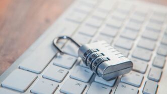 A combination lock rests on a computer keyboard.