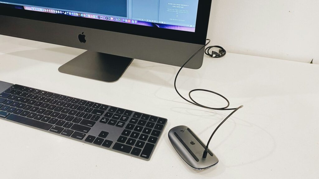 silver imac beside apple magic keyboard and apple magic mouse