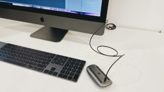 silver imac beside apple magic keyboard and apple magic mouse