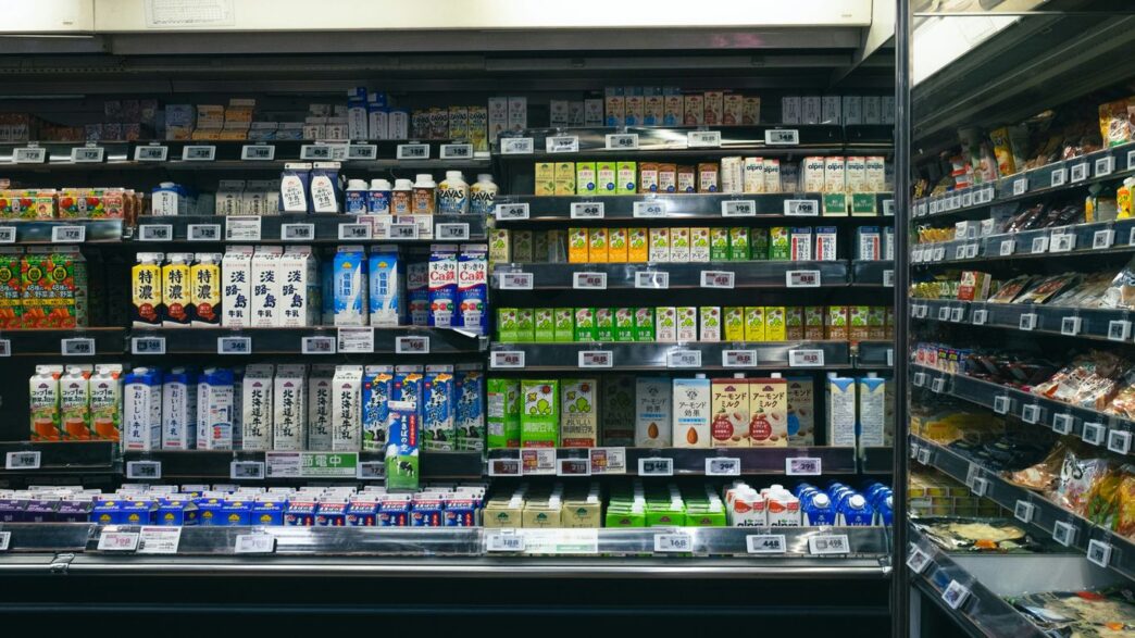 Shelves stocked with beverages and food items in a store.