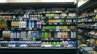 Shelves stocked with beverages and food items in a store.