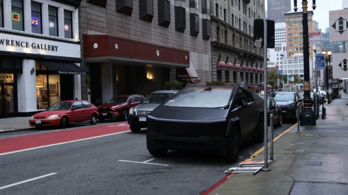 A black tesla cybertruck parked on a city street.