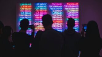 a group of people standing in front of a colorful wall
