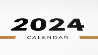 a white wall with a black and orange calendar on it