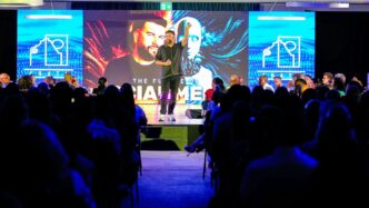 Speaker presenting on stage to an audience