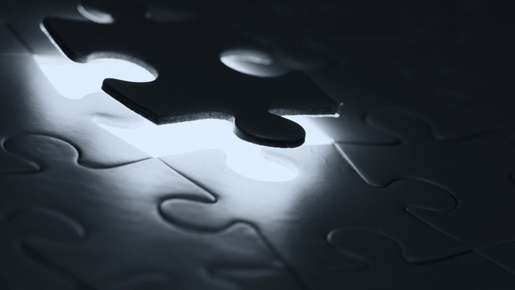 black puzzle piece on white paper