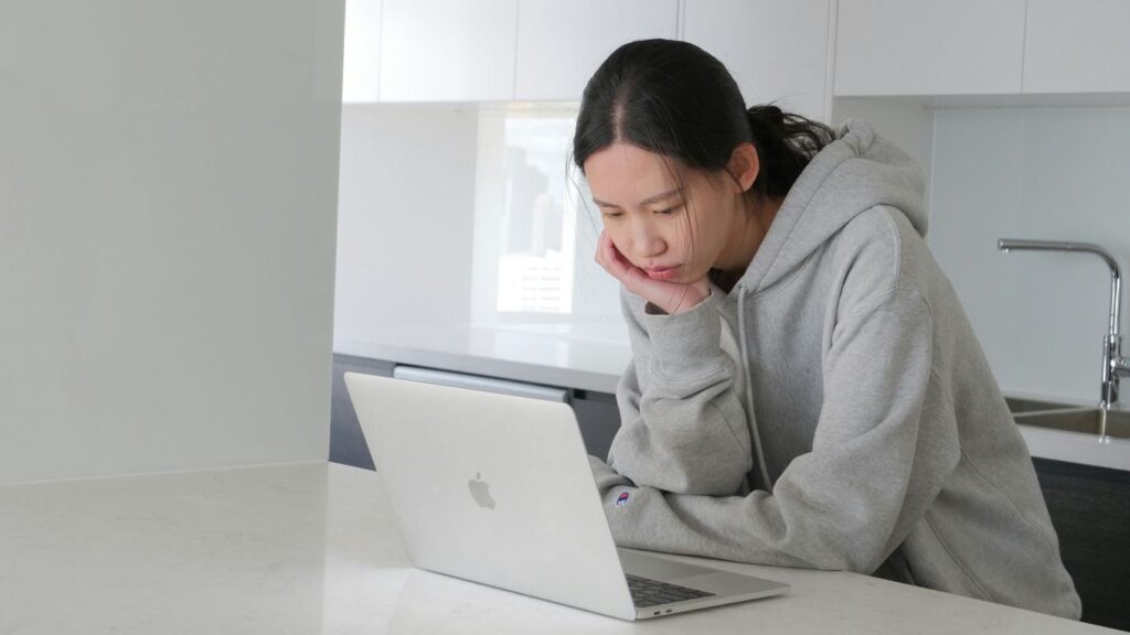 man in gray hoodie sitting beside white table