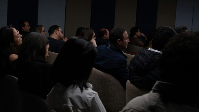 a group of people sitting in a dark room