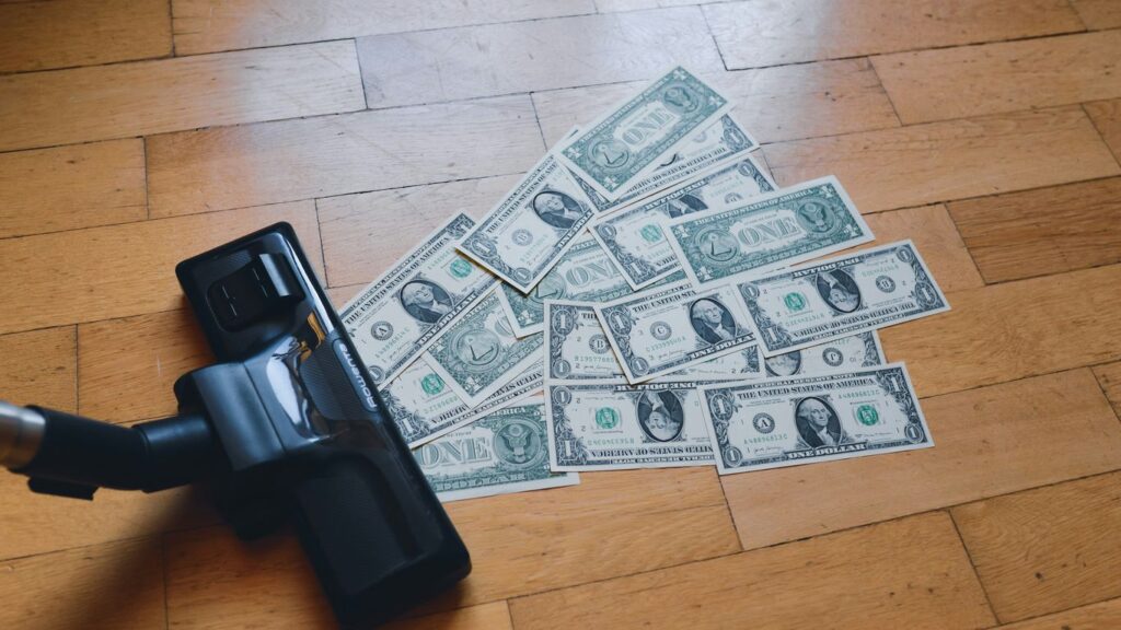 a pile of money sitting on top of a wooden floor