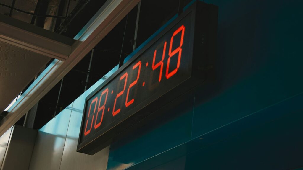a large red clock mounted to the side of a building