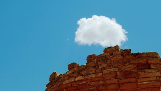 A single cloud floats above ancient stone ruins.