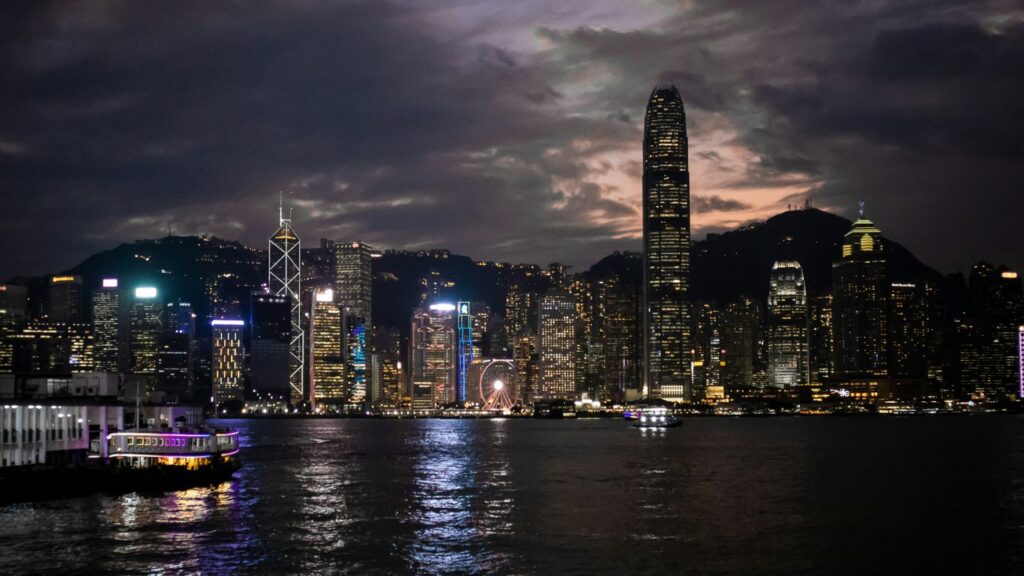 a city skyline at night with a boat in the foreground