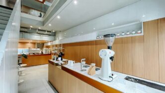 A kitchen with a counter, sink, and stairs