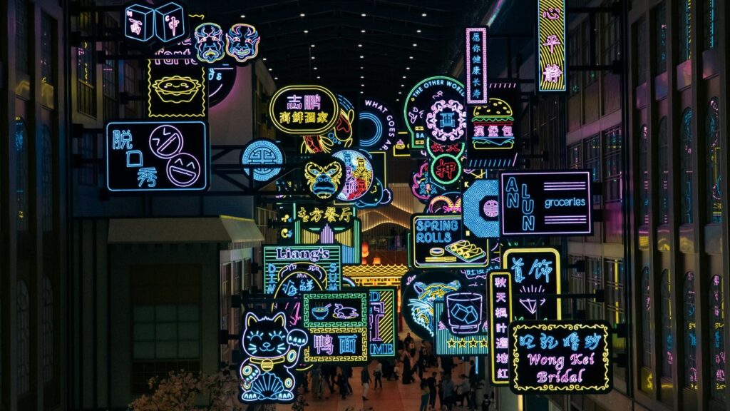 A group of people walking through a mall filled with neon signs
