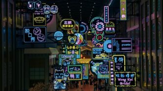 A group of people walking through a mall filled with neon signs