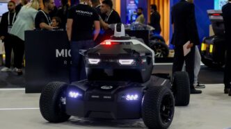 A futuristic security robot with flashing lights on display.