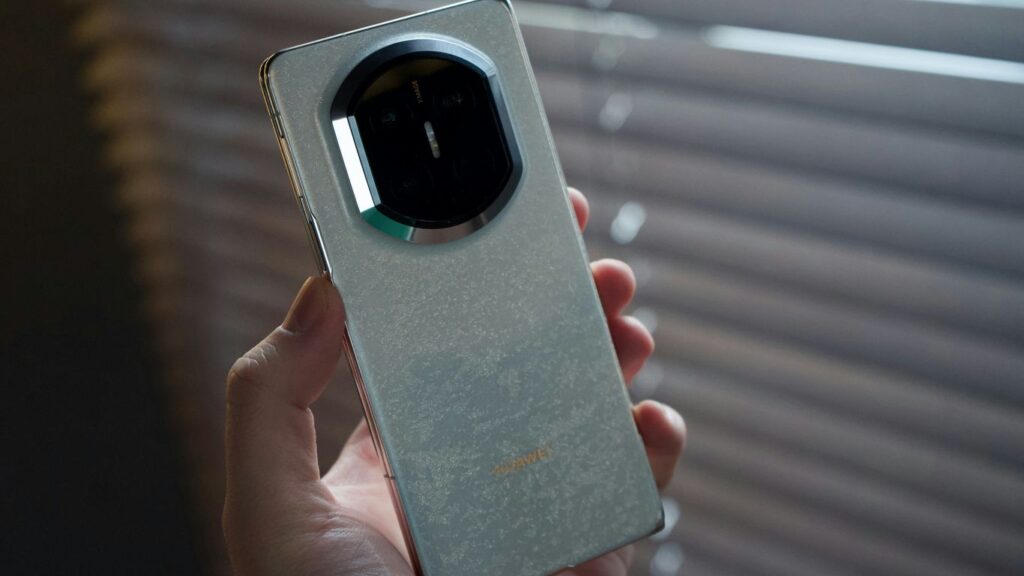 Hand holding a vintage smartphone with a circular camera lens.