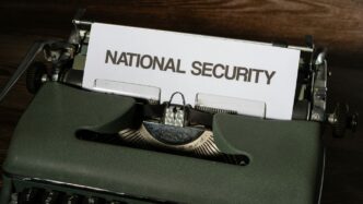 a close up of a typewriter with a national security sign on it