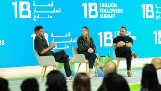 Three people on stage at a summit