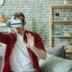 Man wearing virtual reality headset at home