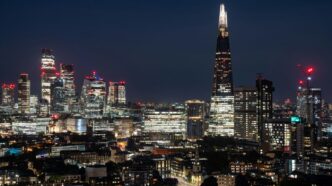A view of a city at night from the top of a hill
