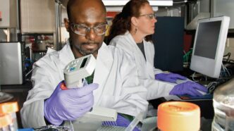 man in white button up shirt holding white and green plastic container