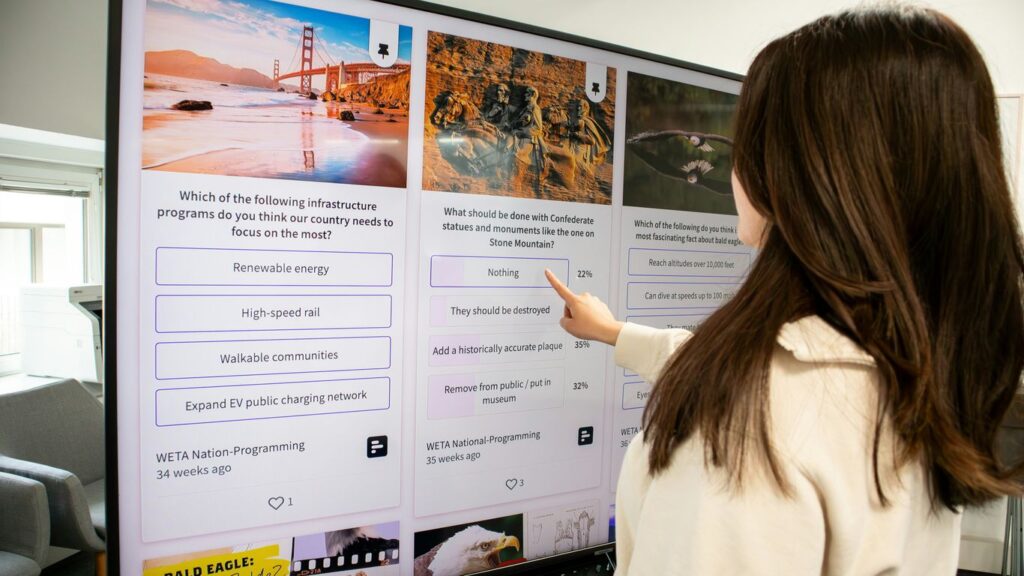 a woman pointing at a poster on a wall