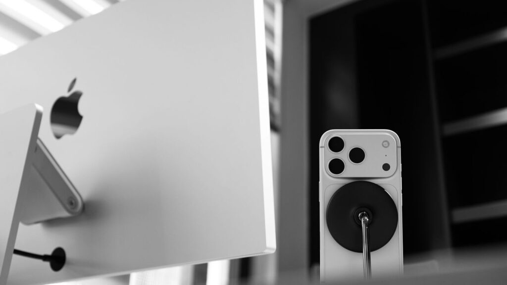 Apple computer monitor with iPhone and charger