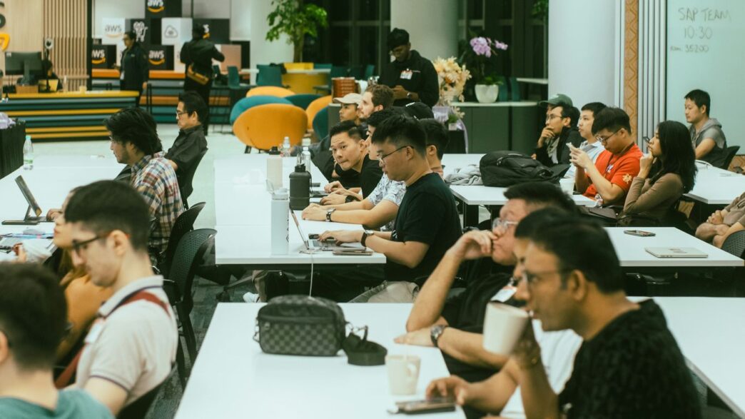 A group of people sitting at tables with laptops