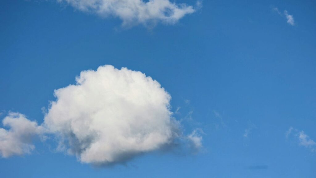a white cloud floating in a blue sky