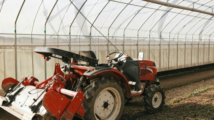 a red tractor is parked in a greenhouse