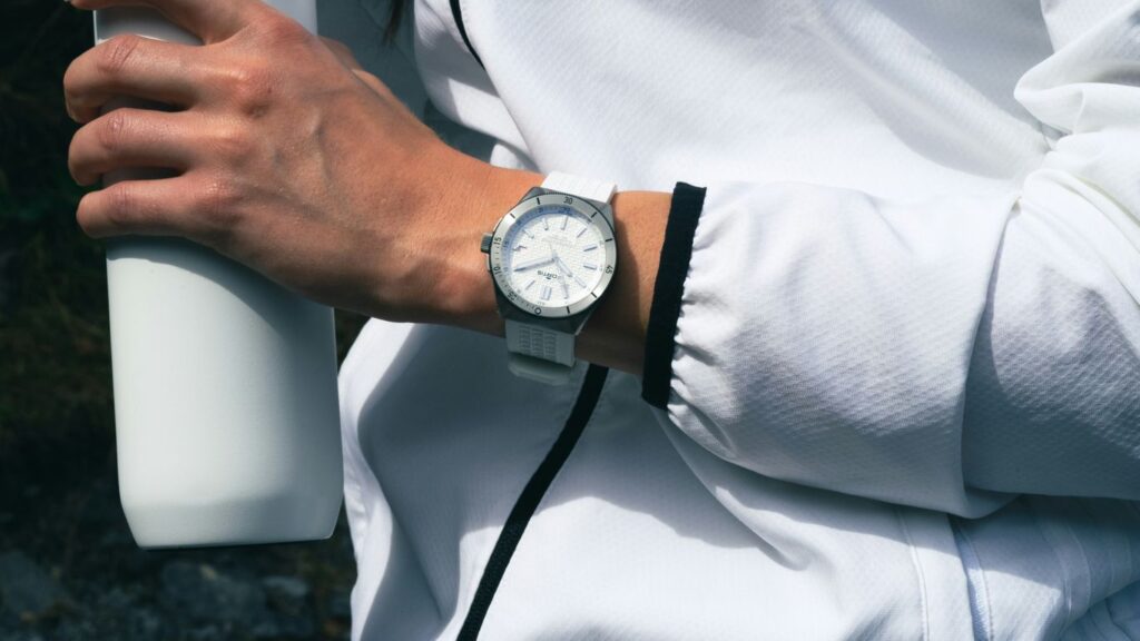 a person with a watch on their wrist holding a white bottle