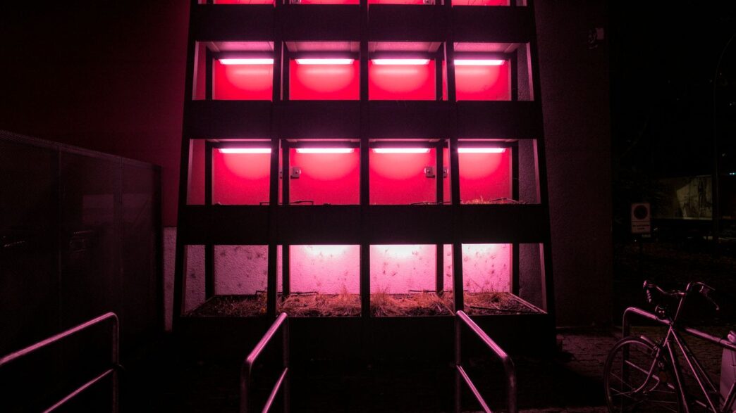 Modern building facade illuminated with bright pink lights