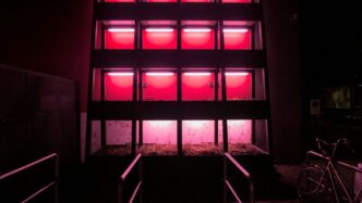 Modern building facade illuminated with bright pink lights