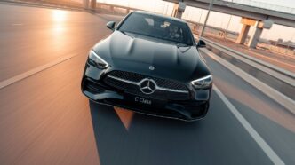 Black mercedes c-class driving on highway at sunset